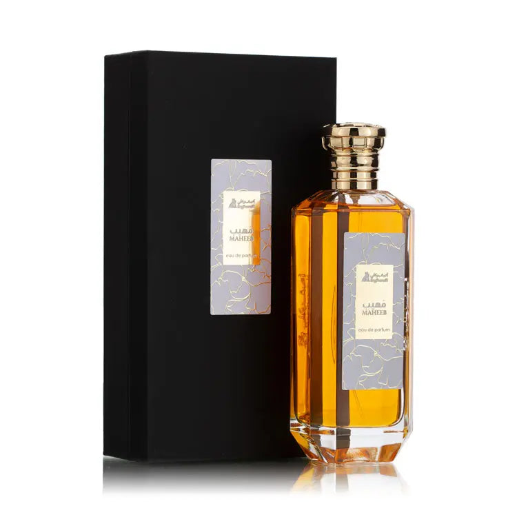 A bottle of Maheeb Eau de Parfum with a yellowish liquid inside, featuring a floral design on the label and a golden cap